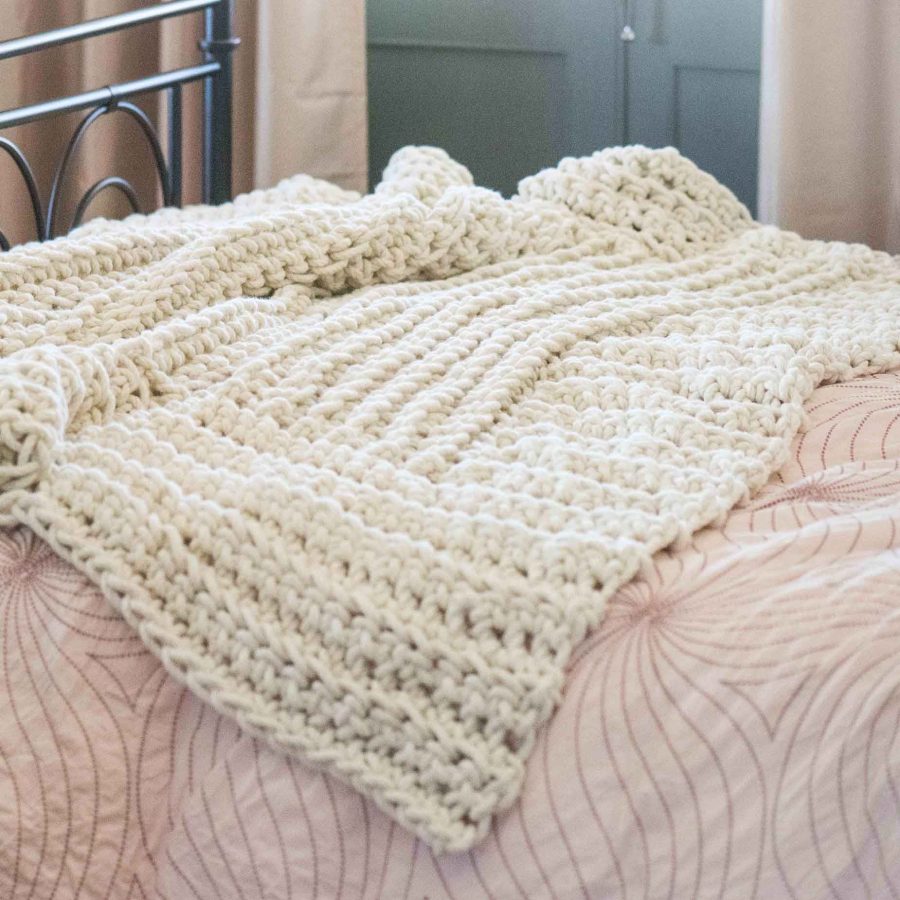 The Macarla Blanket (by Homelea Lass) lying on a bed ready to be snuggled. It can be custom designed to suit your needs.